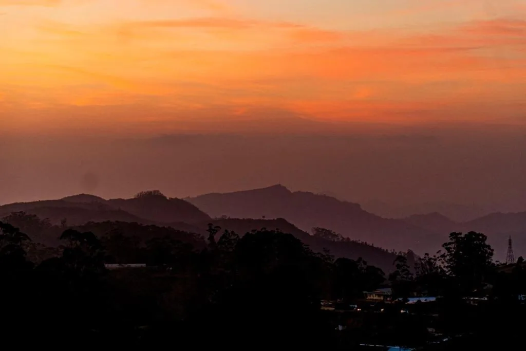 Orange sunset over layered mountain ridges in the hill country